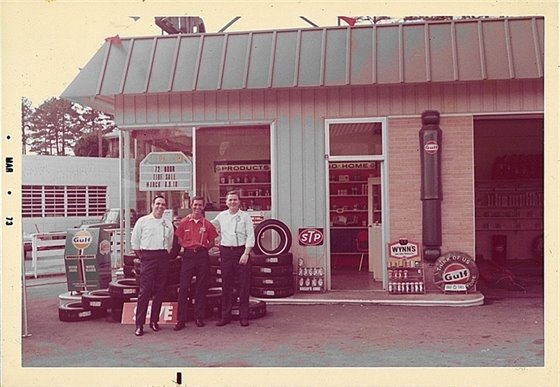 Owner of Red Bank Service Center, Kenneth Combs, stands in the middle of two gentlemen in front of his business. 